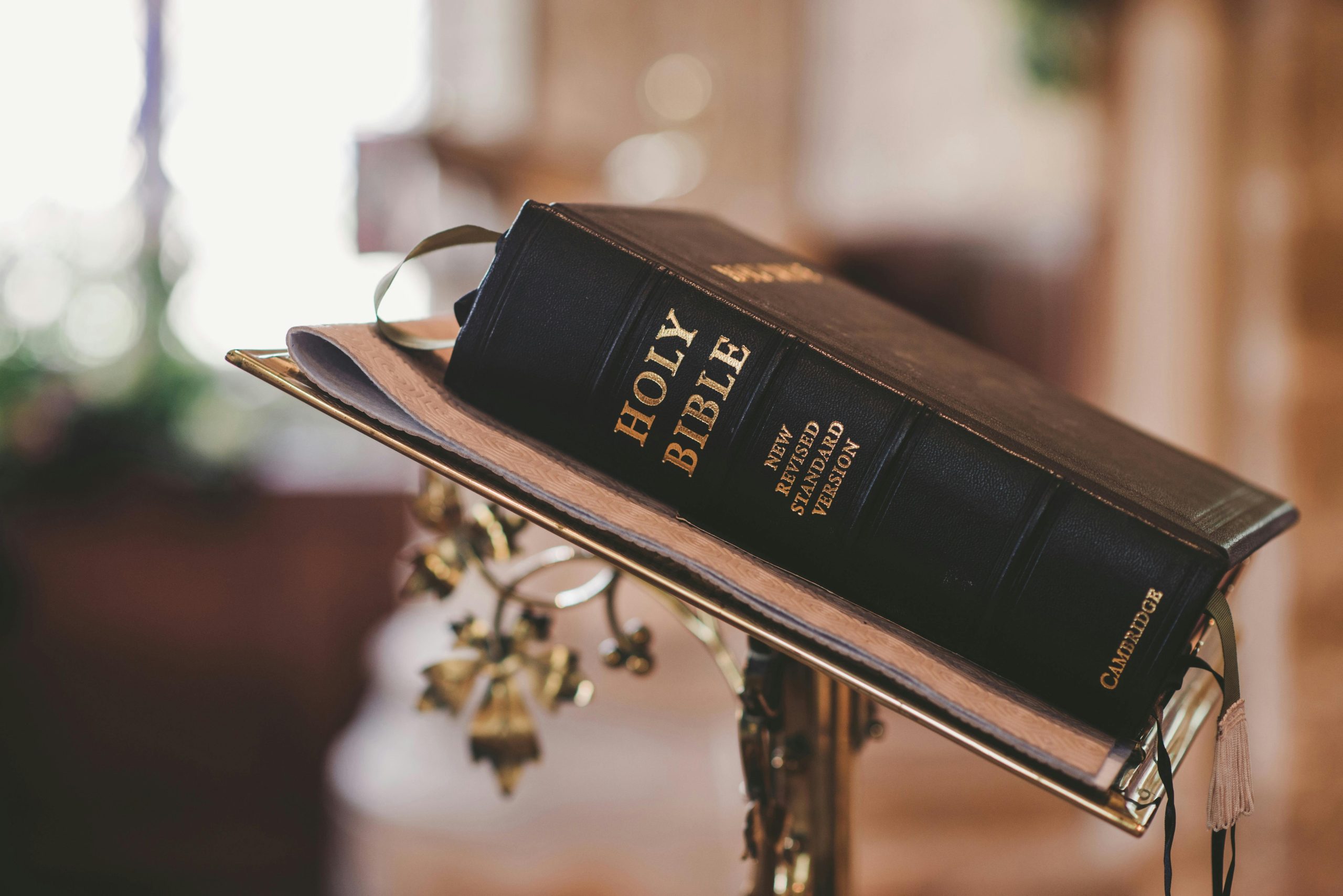 Academics Holy Bible open on a stand inside a church, symbolizing faith and spirituality.